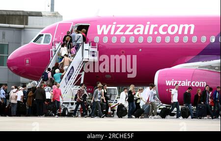 Photo de dossier datée du 20/07/11 de passagers montant à bord d'un avion Wizz Air à l'aéroport de Luton. La pire compagnie aérienne pour les retards de vols britanniques au cours des deux dernières années a insisté sur le fait que les passagers "devraient lui faire confiance" cet été. Marion Geoffroy, directrice générale de Wizz Air au Royaume-Uni, a déclaré que le transporteur hongrois avait revu « chaque aspect de ses opérations » pour renforcer sa résilience, et qu'il avait obtenu de bons résultats ces derniers mois. Depuis 2022, elle a révisé les horaires de vol, les listes de vols et la disponibilité des pièces détachées pour avions. Date d'émission : samedi 15 juillet 2023. Banque D'Images