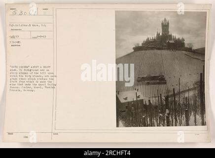 Le sergent Chas.E Mace a pris cette photographie étiquetée « Burg Cochem » après une forte chute de neige à Cochem, Moselle, Prusse rhénane, Allemagne. L'image montre les pentes abruptes de la colline sur laquelle se trouve le burg, couvert de neige. En outre, les vignes peuvent être vues au premier plan, connues pour produire le vin qui a rendu célèbre la vallée de la Moselle. Note : la dernière phrase de la description originale ('$30%!') semble être sans rapport ou hors contexte. Banque D'Images