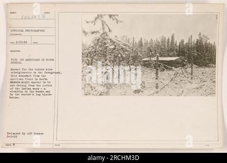 'Instantané du front américain en Russie du Nord pendant la première Guerre mondiale. L'image montre une clairière dans les bois avec un blockhaus en rondins au centre. Des enchevêtrements de fils barbelés sont visibles au premier plan. Photographie prise par le photographe officiel Reco le 1-31-19. Publié par AEP Censor le 2-1-19.' Banque D'Images