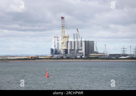 Hartlepool Advanced Gas Cooled Reactor Nuclear Power Station (réacteur avancé refroidi au gaz de Hartlepool) éclipsé par la grue du navire de soutien offshore Voltaire qui est actuellement employé Banque D'Images