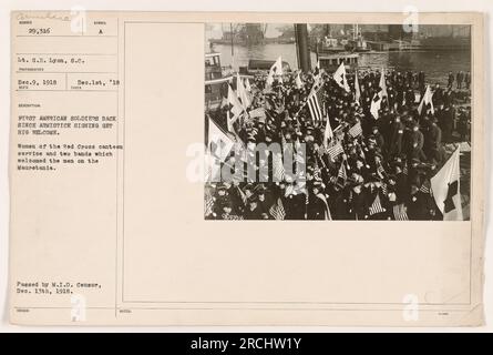 Les soldats rentrant chez eux après la signature de l'armistice sont accueillis chaleureusement. Des femmes de la Croix-Rouge de service de cantine et deux bandes attendent l'arrivée des soldats sur la Mauretania. Cette photographie a été prise le 9 décembre 1918 et est passée par le M.I.D. Censurer le 13 décembre 1918. Banque D'Images