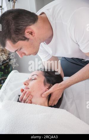 Thérapeute faisant une séance avec massage localisé dans la région du crâne avec l'application de petites pressions douces. Thérapie craniosacrale. Banque D'Images