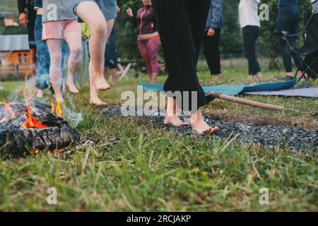 Marche au charbon ou marche au feu. Personne pieds nus sur du bois brûlé et des braises chaudes. Entraînement de la volonté et de la force pour la guérison. initiation et foi Banque D'Images