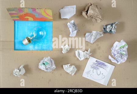 Penser à l'extérieur de la boîte, innovation, idée, vision, concept d'affaires, boîte grundy avec papier froissé et ampoule, symbolique et méataphorique Banque D'Images