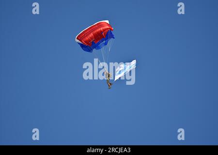 Marseille, France. 14 juillet 2023. Un parachutiste survole le Vieux-Port de Marseille à l’occasion de la cérémonie militaire de la fête nationale. Défilé aérien militaire au-dessus du Vieux-Port de Marseille à l'occasion de la cérémonie militaire de la fête nationale. Crédit : SOPA Images Limited/Alamy Live News Banque D'Images