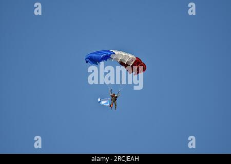 Marseille, France. 14 juillet 2023. Un parachutiste survole le Vieux-Port de Marseille à l’occasion de la cérémonie militaire de la fête nationale. Défilé aérien militaire au-dessus du Vieux-Port de Marseille à l'occasion de la cérémonie militaire de la fête nationale. Crédit : SOPA Images Limited/Alamy Live News Banque D'Images