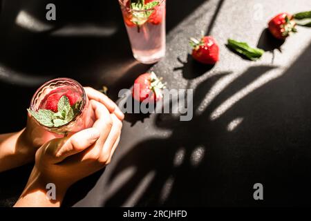 Thé glacé aux fraises. Une boisson rafraîchissante et saine pour les chaudes journées d'été. Thé à la fraise maison versé sur des glaçons dans un verre, offrant un éclat de Banque D'Images