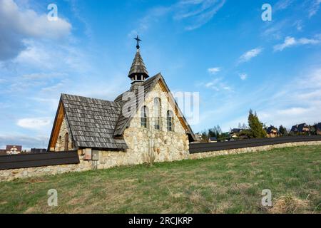 MURZASICHLE, POLOGNE - 28 AVRIL 2023 : petite chapelle en pierre avec une croix sur un toit dans le cimetière Murzasichle en Pologne dans les Hautes Tatras Banque D'Images