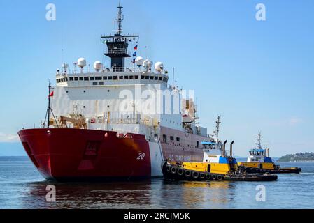 Seattle, États-Unis. 11 juillet 2023. Aux États-Unis Le brise-glace moyen Healy Cutter de la Garde côtière est assisté par deux remorqueurs lorsqu'il quitte le port de Seattle pour le déploiement annuel dans l'Arctique, le 11 juillet 2023 à Seattle, dans l'État de Washington. Le Cutter sera déployé dans le cadre d’une mission de plusieurs mois qui mènera l’équipage dans la région de l’extrême-Arctique. Crédit : PO Steve Strohmaier/États-Unis Garde côtière/Alamy Live News Banque D'Images