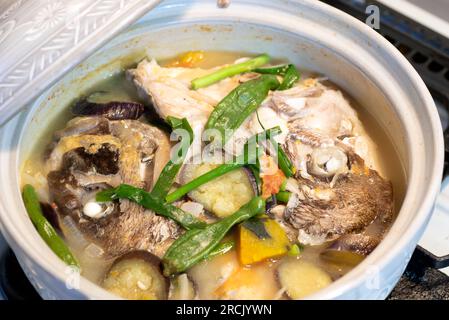 Ragoût de tête de poisson dans un pot en céramique. Sinabawang ulo ng isda. Banque D'Images