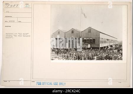 Soldats en uniforme debout en formation, levant et saluant le drapeau américain. Ils chantent l'hymne national, 'The Star-Spangled Banner'. Cette image capture l'esprit patriotique pendant la première Guerre mondiale Usage officiel seulement, émis et reçu le 6 septembre 1918. Photographie prise par le photographe OPI. Banque D'Images