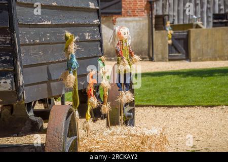 famille scarecrow debout devant une cabane de bergers dans une cour de ferme Banque D'Images