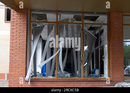 Fenêtres brisées du bâtiment civil de l'explosion de la bombe. Des éclats de verre dépassent dangereusement dans le cadre de la fenêtre. Guerre entre l'Ukraine et la Russie. Cassé c Banque D'Images