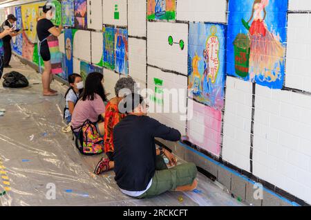 Des bénévoles peignent des peintures murales sur le mur du métro où North Boat Quay passe sous Coleman Bridge, Singapour Banque D'Images