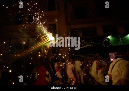 Des foules de gens assistent à la fête du festival de taureaux de feu pendant le San Fermín 2023. À 9:45 heures, l'événement de la bulle de feu est célébré, mieux connu sous le nom de 'Torico de Fuego', il attire les enfants et les adultes. Un taureau simulant avec un cadre en carton traverse les rues, et sur son dos il porte plusieurs fusées de feu colorées. Banque D'Images