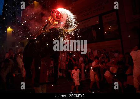 Des foules de gens assistent à la fête du festival de taureaux de feu pendant le San Fermín 2023. À 9:45 heures, l'événement de la bulle de feu est célébré, mieux connu sous le nom de 'Torico de Fuego', il attire les enfants et les adultes. Un taureau simulant avec un cadre en carton traverse les rues, et sur son dos il porte plusieurs fusées de feu colorées. Banque D'Images