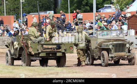 Deux jeeps avec des personnages historiques habillés en soldats de l'armée américaine dans l'arène principale du Tankfest au musée des chars de Bovington Banque D'Images