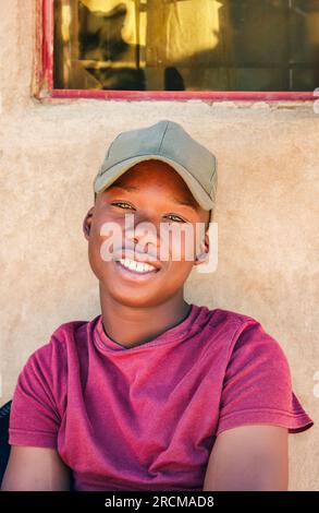 jeune africain dans le village assis devant sa maison Banque D'Images