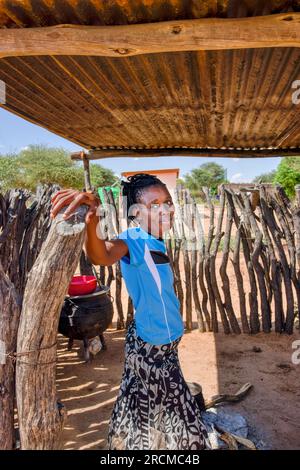 jeune femme africaine de village debout sous le hangar d'une cabane de cuisine en plein air pour se rafraîchir Banque D'Images