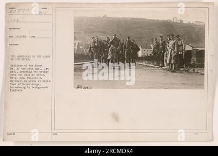 Des soldats américains du 1e bataillon du 28e régiment d'infanterie, 1e division, peuvent être vus traversant un pont sur la Moselle. Le brigadier général Francis C. Marshall est présent dans un groupe à droite. La photographie a été prise à Wormeldange, Luxembourg. Banque D'Images