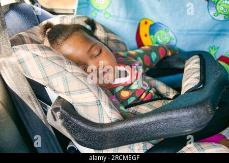 Portrait de bébé africain endormi rapidement dans le siège d'auto pour enfant, à l'arrière Banque D'Images