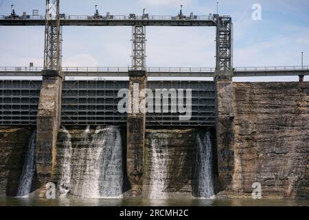 Vieux barrage hydroélectrique montrant des déversoirs et des lignes électriques Banque D'Images