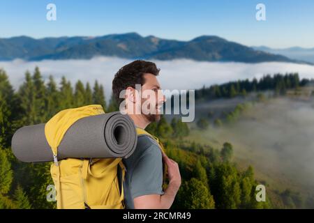 Touriste heureux avec sac à dos jaune dans les montagnes Banque D'Images