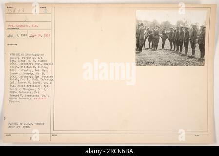 Groupe de soldats recevant des médailles du général Pershing. De gauche à droite : 1st Lieutenant C.R. Holmes du 26th Infantry, Sergent d'approvisionnement régimentaire William M. Norton du 18th Infantry, Sergent James A. Murphy de la compagnie B. 26th Infantry, Sergent Patrick Welsh de la compagnie 1, 18th Infantry, Caporal Ernest W. Birch de la compagnie B 6th Field Artillery, Caporal Henry J. Mongeau de la compagnie 1, 28th Infantry, et le soldat Edward V. Armstrong de la compagnie 1, 28th Infantry. Localisation : Paillard, France. Date : 23 juillet 1918. Passé par A.E.F. Censor. [remarque : légende factuelle] Banque D'Images