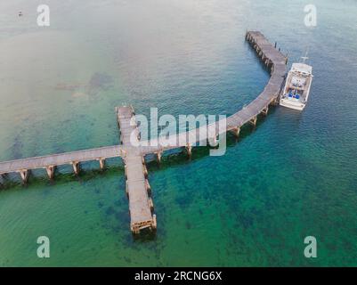 Un bateau de pêche solitaire attaché à une jetée courbe au-dessus d'une baie calme à venus Bay sur la péninsule de Yorke en Australie méridionale Banque D'Images