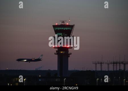 Steenokkerzeel, Belgique. 15 juillet 2023. La photo d'illustration montre un avion qui survole la tour de contrôle de Brussels Airport de nuit, à Zaventem, samedi 15 juillet 2023. Le ministre fédéral de la mobilité Gilkinet (Ecolo) a présenté cette semaine un projet de décret ministériel visant à limiter les nuisances sonores pour les résidents vivant à proximité de l’aéroport internatinoal. Une mesure frappante est l'interdiction totale des vols de nuit à partir de 11 heures et 6 heures du matin BELGA PHOTO NICOLAS MAETERLINCK crédit : Belga News Agency/Alamy Live News Banque D'Images