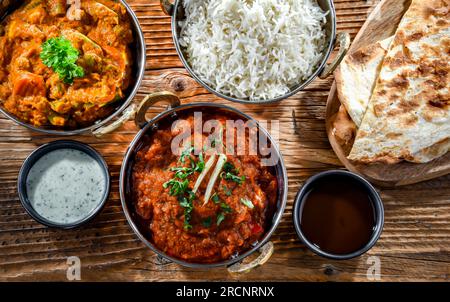 Paneer de madras chaud et masala de légumes avec riz basmati servi dans des pots de karahi indiens originaux. Banque D'Images