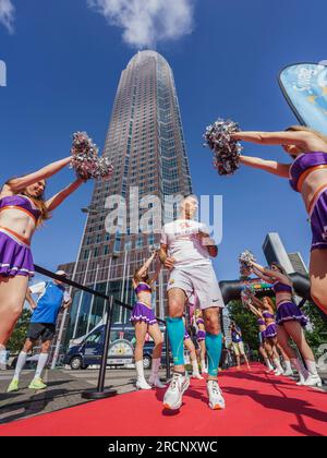 Francfort, Allemagne. 16 juillet 2023, Hesse, Frankfurt/main : Hassan Kurt commence sa course d'escalier à travers une ligne de cheerleaders Frankfurt Galaxy. Il veut courir les escaliers plusieurs fois et en sens inverse. Le 'SkyRun Messeturm Frankfurt' est une course de coupe du monde et un escalier caritatif qui monte jusqu'au 61e étage du Frankfurt Messeturm. Crédit : dpa Picture alliance/Alamy Live News Banque D'Images