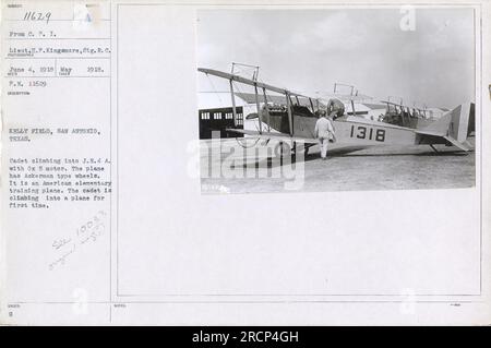 Cadet à Kelly Field à San Antonio, Texas, grimpant dans un J.N.4 A avec moteur Ox 5. L'avion est équipé de roues de type Ackerman et est un avion d'entraînement élémentaire américain. Cette photo capture la première fois que le cadet monte dans l'avion. Banque D'Images