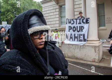 Londres, Royaume-Uni. 14 juillet 2023. Un manifestant tient une banderole devant l'ambassade de France à Londres pendant la manifestation. Merzouk, 17 ans, a été abattu par un policier lors d'un arrêt de circulation le 27 juin dans la banlieue parisienne de Nanterre, sa mort a donné lieu à des manifestations où des symboles de l'Etat tels que des mairies, des commissariats et d'autres bâtiments ont été attaqués. La protestation de Justice for Nahel UK, BLM UK et des militants à travers le Royaume-Uni était d'exprimer leur solidarité avec la campagne Justice pour Nahel. (Photo de Thabo Jaiyesimi/SOPA Images/Sipa USA) crédit : SIPA USA/Alamy Live News Banque D'Images