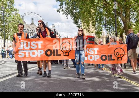 Londres, Royaume-Uni. 15 juillet 2023. Les militants de Just Stop Oil marchent avec des banderoles à Westminster alors qu’ils poursuivent leurs marches lentes quotidiennes exigeant que le gouvernement cesse de délivrer de nouvelles licences pour les combustibles fossiles. Banque D'Images