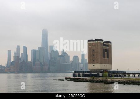 Vue panoramique depuis le front de mer de Jersey City, NJ, États-Unis vers Lower Manhattan brumeux et couvert, New York City avec des gratte-ciel de l'autre côté de Hudson Banque D'Images