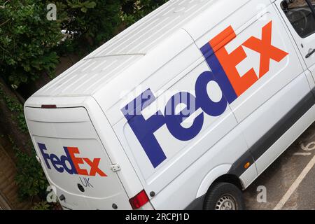 Fourgon de livraison blanc FedEx avec logo FedEx et décoration garé devant une maison en Angleterre. Thème : envois b2b, livraison express, livraison de colis Banque D'Images