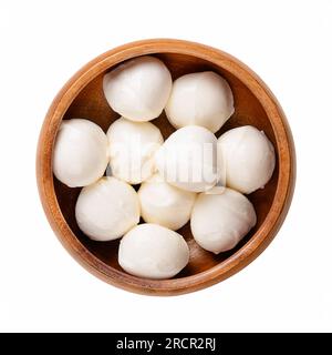 Mini boules de mozzarella, dans un bol en bois. Fromage blanc frais du sud de l'Italie fabriqué à partir de lait selon la méthode des pâtes filata, également appelé bambini bocconcini. Banque D'Images