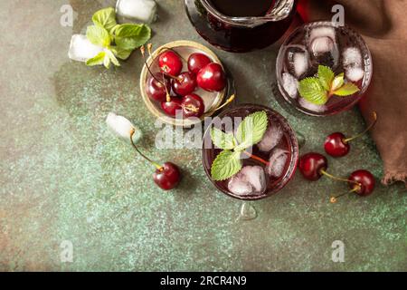 Cola de cerise rafraîchissante froide dans un verre avec de la glace sur un fond de pierre, jus d'été. Vue d'en haut. Espace de copie. Banque D'Images