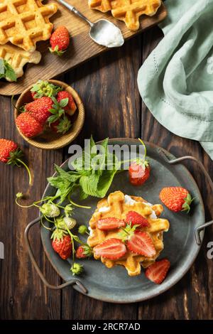 Gaufres belges avec fraises berrie fraîches et ricotta pour le petit déjeuner sur une table rustique. Vue d'en haut. Banque D'Images