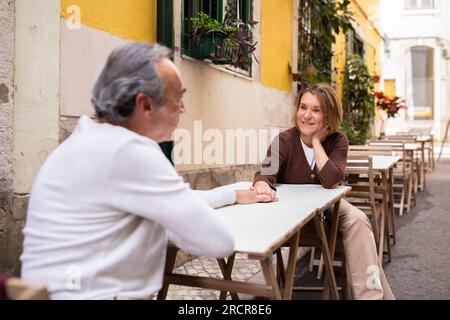 Couple mûr assis à Table au café dehors, se tenant la main Banque D'Images
