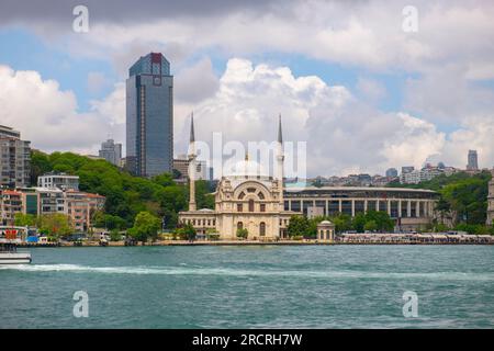 Mosquée Dolmabahce Camii avec le bâtiment Suzer Plaza à l'arrière-plan au détroit du Bosphore au bord de l'eau dans le quartier Beyoglu dans la ville historique d'Istanbul, Tur Banque D'Images