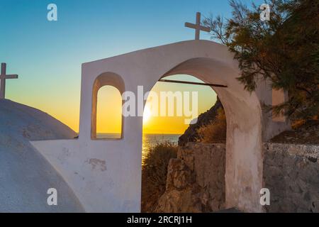 Lever du soleil sur la côte de la mer Égée vu de la vieille église orthodoxe à Kamari plage, station balnéaire sur la côte est de Santorin, Cyclades, Grèce, sept 2013 Banque D'Images