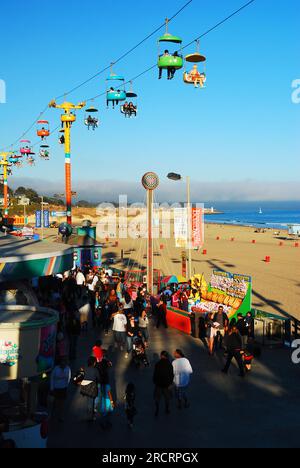 Le parachutiste survole les gens qui marchent le long de la promenade de Santa Cruz un jour de vacances d'été Banque D'Images