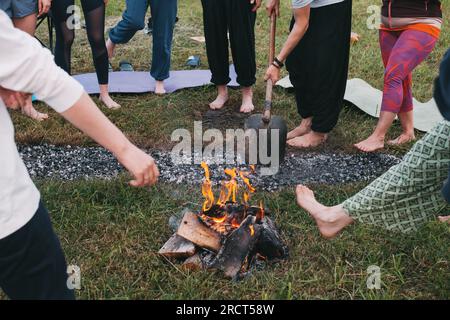 Marche au charbon ou marche au feu. Personne pieds nus sur du bois brûlé et des braises chaudes. Entraînement de la volonté et de la force pour la guérison. initiation et foi Banque D'Images