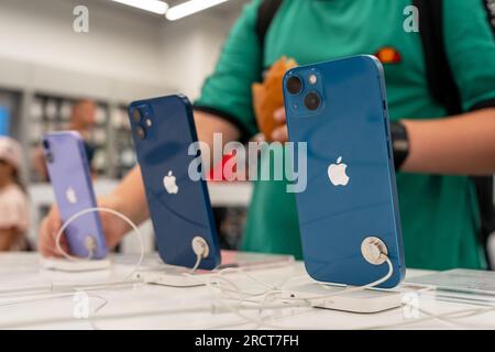 Vue arrière des nouveaux smartphones iPhone dans l'Apple Store. L'acheteur regarde et essaie un nouveau gadget pour l'achat. Minsk, Biélorussie, 17 juillet 2023 Banque D'Images