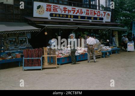 Vintage circa 1950 photographie, magasin en plein air ou marché probablement à Tokyo, Japon. Signez pour les caramels et bonbons Morinaga. SOURCE : TRANSPARENCE 35MM Banque D'Images
