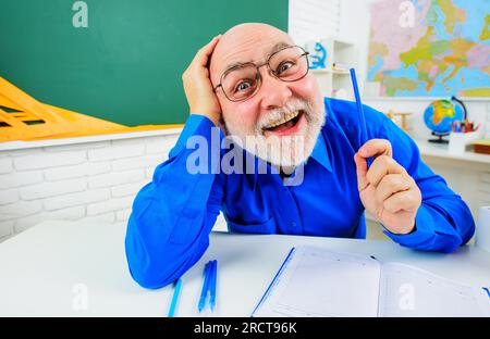 Journée des enseignants. Retour à l'école. Professeur positif dans des lunettes avec crayon et cahier. Apprentissage et éducation. Enseignant se préparant à la leçon en classe Banque D'Images