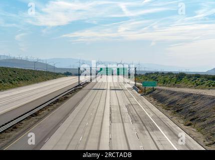 Prenez l'Interstate 10 en Californie près de Palm Springs et Indio California. Pas de voitures sur l'autoroute et moulins à vent en arrière-plan. Banque D'Images