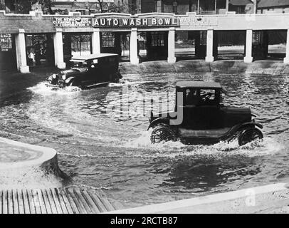 Chicago, Illinois : 20 septembre 1924 Une nouvelle méthode de lavage des automobiles à Chicago. Deux voitures à la fois traversent le bol de lavage automatique pour nettoyer la boue et la saleté des roues et des essieux. Banque D'Images